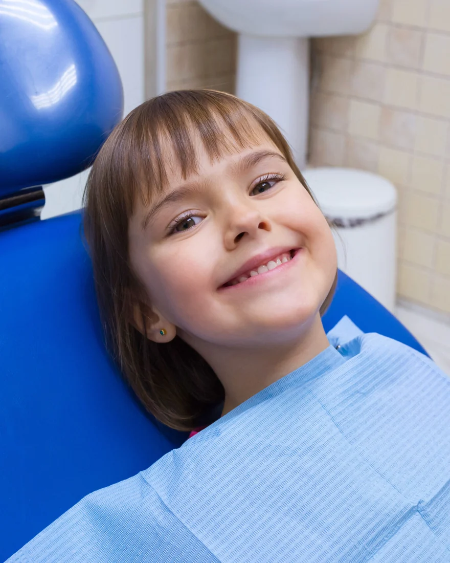 Niña sonriendo en el sillón dental